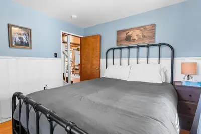 a bed in a bedroom with blue walls at Dream Street Escape -Private Hot Tub, near the Village and Lake! in Big Bear Lake