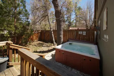 a jacuzzi tub sitting on the side of a deck at Dream Street Escape -Private Hot Tub, near the Village and Lake! in Big Bear Lake