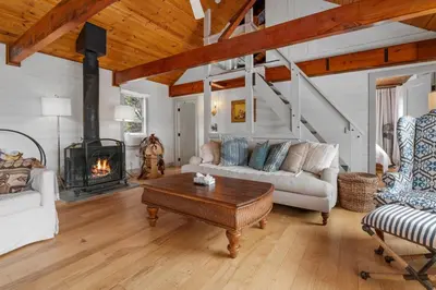 a living room with a couch and a fireplace at Enchanted Hideaway - Newly remodeled with Hot Tub and Lake Views! in Fawnskin