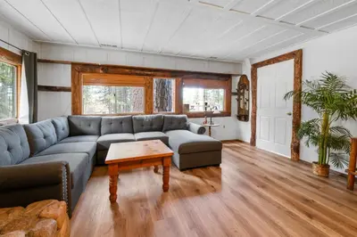 a living room with a couch and a table at Evergreen Paradise - Beautiful newly remodeled cabin with Hot Tub and Game Room! in Big Bear Lake