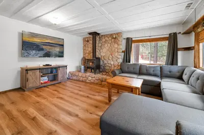 a living room with a couch and a table at Evergreen Paradise - Beautiful newly remodeled cabin with Hot Tub and Game Room! in Big Bear Lake