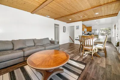 a living room with a couch and a table at Family Fun Cabin - Mountain home with Game Room, Hot Tub and Lake Views! in Fawnskin