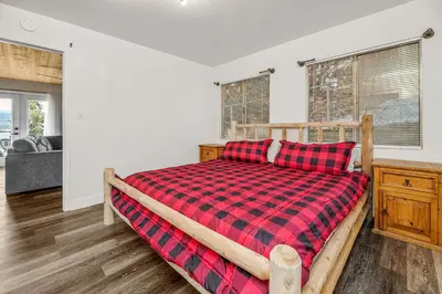 a bedroom with a bed with a red plaid blanket at Family Fun Cabin - Mountain home with Game Room, Hot Tub and Lake Views! in Fawnskin
