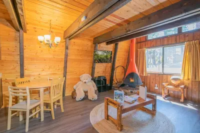 a large teddy bear sitting in the corner of a room at Fanciful Winter's Lake - Mix of old-world charm and modern-day gambrel style cabin! in Big Bear Lake