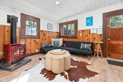 a living room with a couch and a stove at Finns Fish Camp - Walking distance to Lake and Village! Back patio with barbecue, fully fenced yard! in Big Bear Lake
