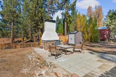 a grill with a picnic table and chairs in a yard at Finns Fish Camp - Walking distance to Lake and Village! Back patio with barbecue, fully fenced yard! in Big Bear Lake