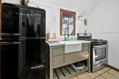 a kitchen with a black refrigerator and a sink at Finns Fish Camp - Walking distance to Lake and Village! Back patio with barbecue, fully fenced yard! in Big Bear Lake