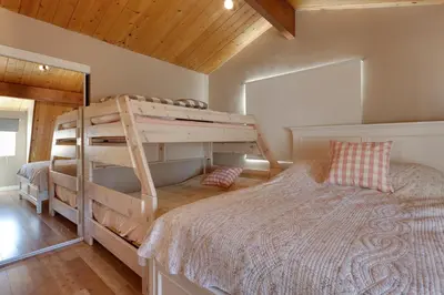 a bedroom with a bunk bed in a house at Five Pines - Beautifully remodeled gambrel cabin with Hot Tub and Fenced Yard! in Big Bear Lake