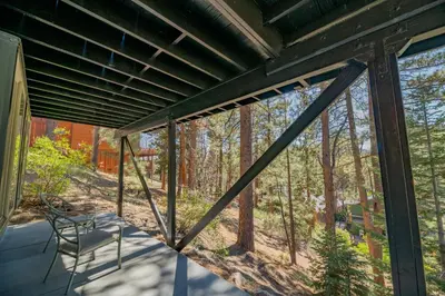 a view from the back porch of a house at Forest Escape - Situated on the quiet side of the lake, nicely decorated contemporary cabin! in Fawnskin