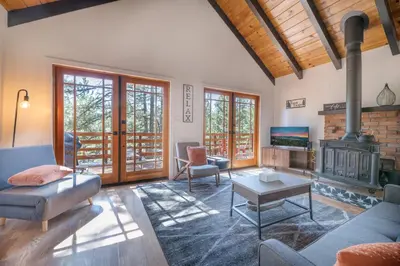 a living room with a couch and a fireplace at Forest Escape - Situated on the quiet side of the lake, nicely decorated contemporary cabin! in Fawnskin