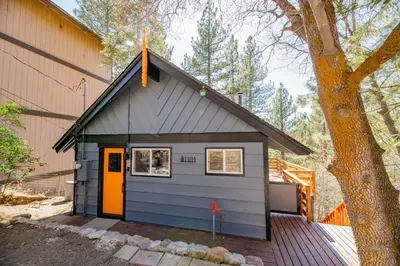 a small shed with a orange door on a house at Forest Escape - Situated on the quiet side of the lake, nicely decorated contemporary cabin! in Fawnskin