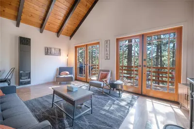 a living room with a couch and a table at Forest Escape - Situated on the quiet side of the lake, nicely decorated contemporary cabin! in Fawnskin