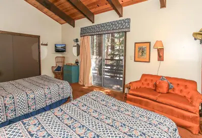 a bedroom with two beds and a couch at Gallagher's West - Pine surrounded deck and barbecue! Bumper Pool and Wet bar! Darts! in Big Bear Lake