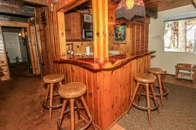 a bar with wooden stools in a room at Gallagher's West - Pine surrounded deck and barbecue! Bumper Pool and Wet bar! Darts! in Big Bear Lake