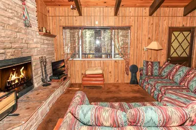 a living room with a couch and a fireplace at Gallagher's West - Pine surrounded deck and barbecue! Bumper Pool and Wet bar! Darts! in Big Bear Lake