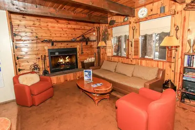 a living room with a couch and chairs and a fireplace at Gallagher's West - Pine surrounded deck and barbecue! Bumper Pool and Wet bar! Darts! in Big Bear Lake