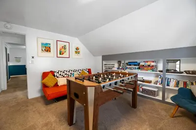 a living room with a foosball table and a couch at Happy Hours - Modern Cabin with Game Room and Peek-a-Boo Lake Views! in Big Bear Lake