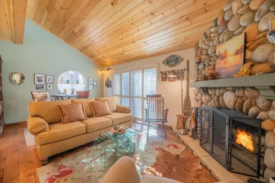 a living room with a couch and a fireplace at Junipine Lakefront Condo - Walking distance to the lake! Less than 2 miles from the slopes! in Big Bear Lake