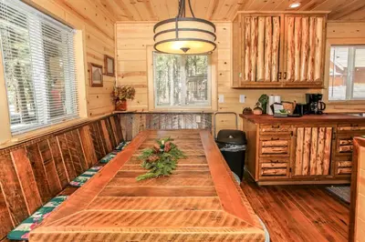 a large wooden table in the middle of a kitchen at Knotty Knight- Walking distance to the lake as well as the Village! in Big Bear Lake