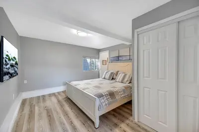 a bedroom with a bed and a white door at Lakefront Oasis - Adorable lakefront cabin with a private beach! in Big Bear Lake