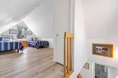 a attic bedroom with two beds and a hallway at Lakefront Oasis - Adorable lakefront cabin with a private beach! in Big Bear Lake