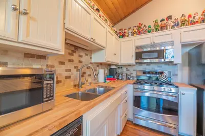 a kitchen with stainless steel appliances and white cabinets at Lakefront Viking Oasis - Beautiful Viking Estates condo complex on the lake! in Big Bear Lake
