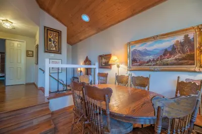 a dining room with a wooden table and a painting on the wall at Lakefront Viking Oasis - Beautiful Viking Estates condo complex on the lake! in Big Bear Lake
