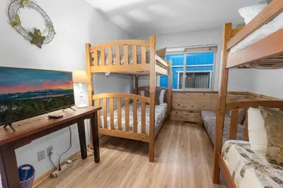 a bedroom with a bunk bed and a desk and a bunk bed at McWhinney The Pooh's Den - Everything you need for a memorable time with family! Pool Table! in Big Bear Lake