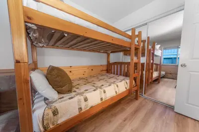 a bedroom with two bunk beds in a house at McWhinney The Pooh's Den - Everything you need for a memorable time with family! Pool Table! in Big Bear Lake