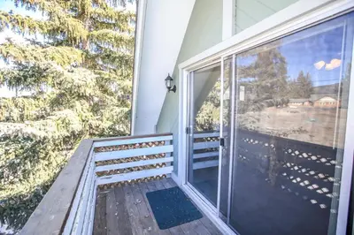 a balcony with a large glass door and a window at Village Hideaway - Perfectly cozy cabin with a beautiful location, walking distance to everything! in Big Bear Lake