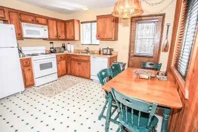 a kitchen with a table and chairs and a refrigerator at Village Hideaway - Perfectly cozy cabin with a beautiful location, walking distance to everything! in Big Bear Lake