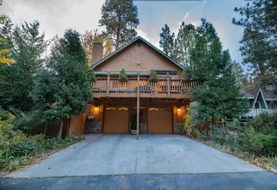 a house with a deck on top of a driveway at Treetop Bearadise - Best mountain living in a nicely furnished and decorated home in Big Bear Lake