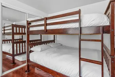 a bunk bed room with three bunk beds at The Rock House - Walk to Big Bear Snow Play! Walk to Oktoberfest! Perfect weekend getaway! in Big Bear City