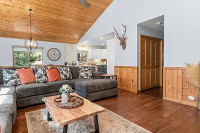 a living room with a couch and a table at The Grizzlies Den - Log style cabin located in the desirable Fox Farm area! Games and arcade! in Big Bear Lake