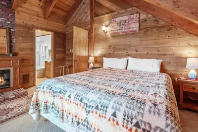 a bedroom with a bed in a log cabin at The Lakehouse Cabin - Located close to the Lake! Hot Tub, Smart TV, and WiFi! in Big Bear Lake