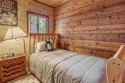 a bedroom with a bed with a teddy bear on it at The Lakehouse Cabin - Located close to the Lake! Hot Tub, Smart TV, and WiFi! in Big Bear Lake