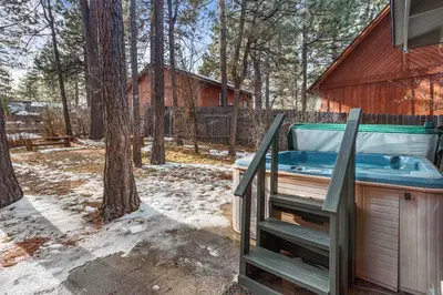 a jacuzzi tub sitting outside of a house at The Lakehouse Cabin - Located close to the Lake! Hot Tub, Smart TV, and WiFi! in Big Bear Lake