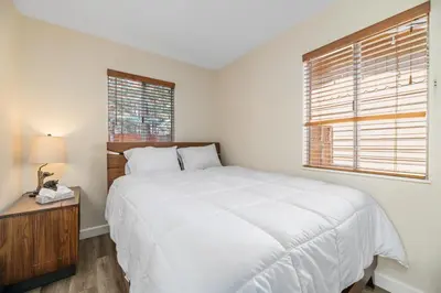 a white bedroom with a large bed and a window at The Bear Den - DREAM LOCATION WALKING DISTANCE TO LAKE AND VILLAGE! in Big Bear Lake