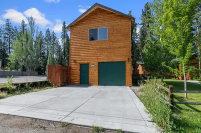 a small wooden building with a green garage at The Bear Den - DREAM LOCATION WALKING DISTANCE TO LAKE AND VILLAGE! in Big Bear Lake