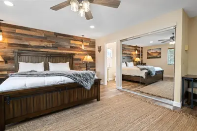 a bedroom with a wooden wall and a bed and a mirror at The Bear Den - DREAM LOCATION WALKING DISTANCE TO LAKE AND VILLAGE! in Big Bear Lake
