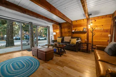 a living room with a couch and a table at The Cozy Bear Cabin - Updated gambrel with huge outdoor space! Cornhole, Tether ball, Fire pit! in Big Bear Lake