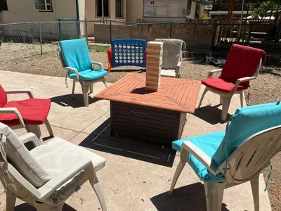 a group of chairs and a table with a vase at The Cozy Bear Cabin - Updated gambrel with huge outdoor space! Cornhole, Tether ball, Fire pit! in Big Bear Lake
