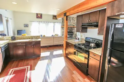 a kitchen with wooden cabinets and a stove top oven at The Fox Paw - Cozy and spacious cabin! Family game room with Foosball and Pool Table! Jet Tub! in Big Bear Lake