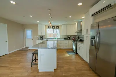 a kitchen with white cabinets and a stainless steel refrigerator at Modern Times - Amazing place with super open concept! Jet tub! in Big Bear Lake