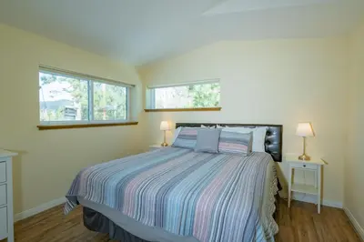 a bedroom with a bed and two windows at Modern Times - Amazing place with super open concept! Jet tub! in Big Bear Lake