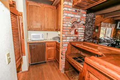 a kitchen with wooden cabinets and a brick wall at Summit Adventure - Beautiful, spacious and quiet home! Foosball, pool and poker table! Jet tub! in Big Bear Lake