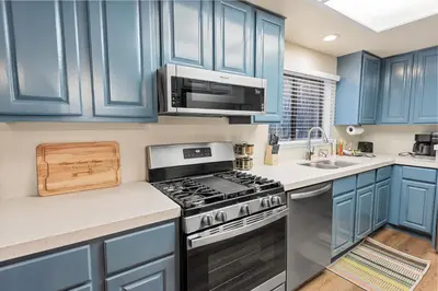 a kitchen with blue cabinets and a stove at Badger Den - Located in the heart of the village in Big Bear Lake
