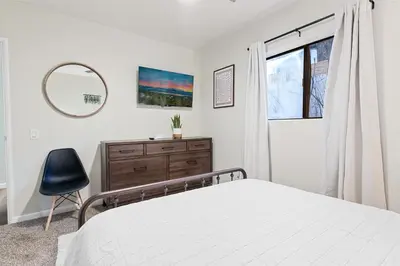 a bedroom with a bed and a mirror and a chair at Badger Den - Located in the heart of the village in Big Bear Lake