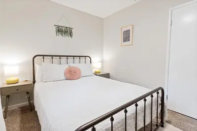 a bedroom with a white bed with a pink pillow at Badger Den - Located in the heart of the village in Big Bear Lake