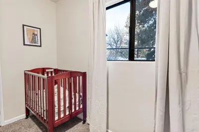 a crib in a room with a window at Badger Den - Located in the heart of the village in Big Bear Lake